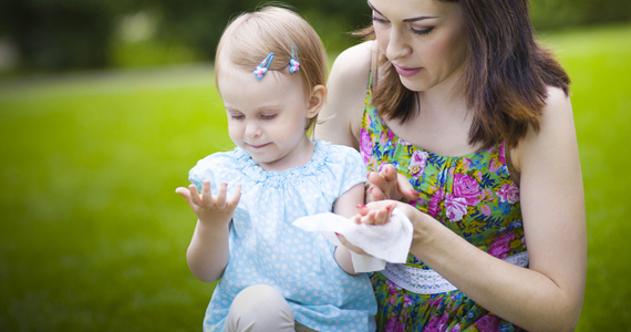 Mother helping girl clean hands with wet wipe illustrates the elegant design in high resolution for Tradis, Inc..