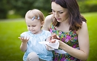 Mother helping girl clean hands with wet wipe illustrates the elegant design in high resolution for Tradis, Inc..